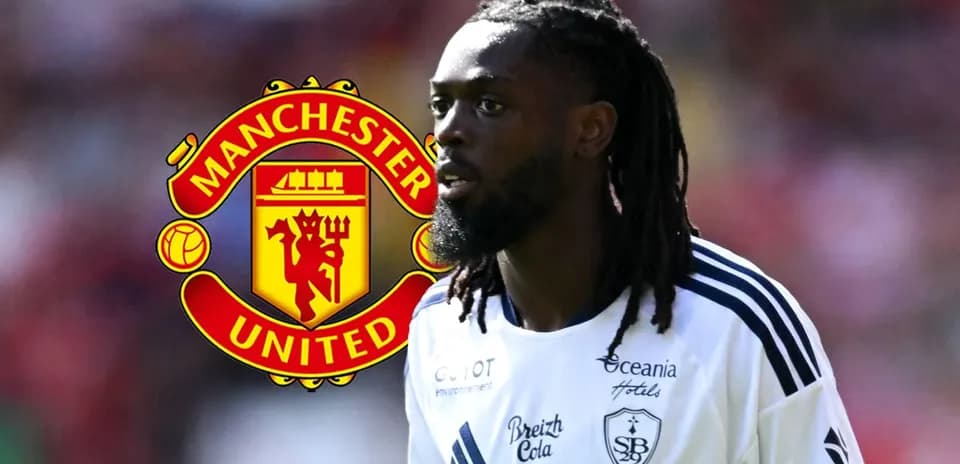 Futbolchi Manchester United logosi oldida