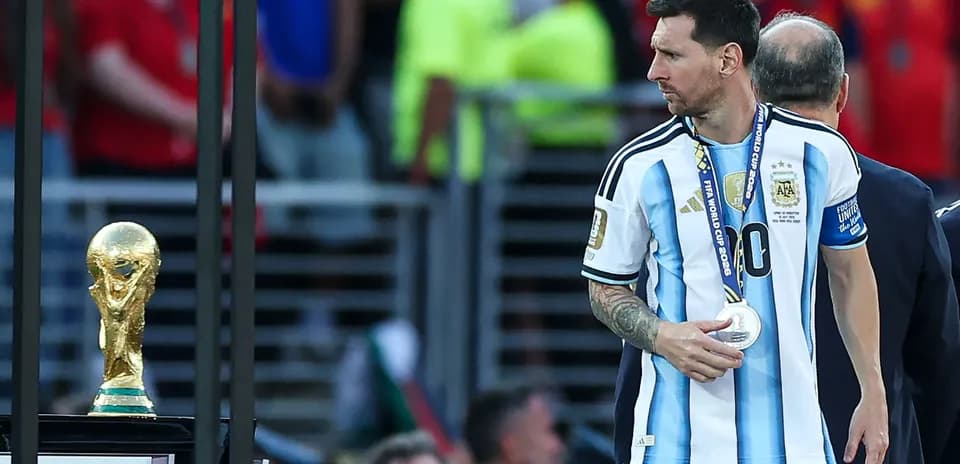 Lionel Messi with silver medal near World Cup trophy