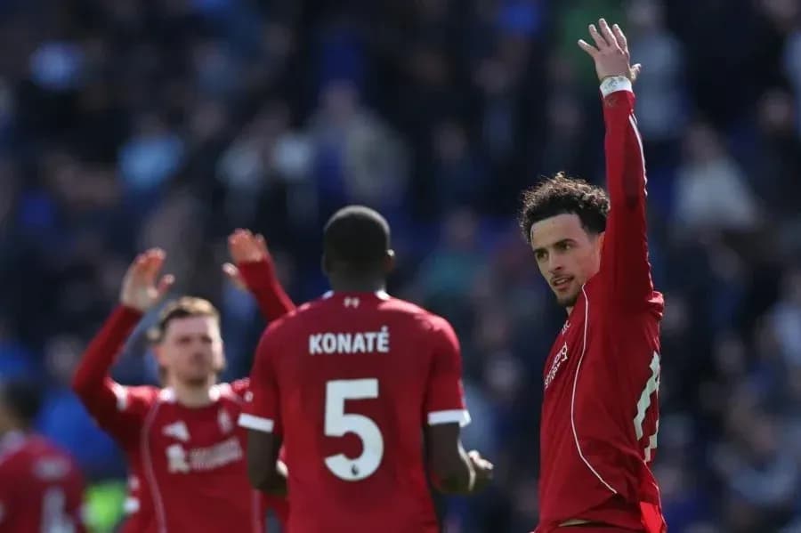 Futbolchilar g'alaba belgisini ko'rsatmoqda