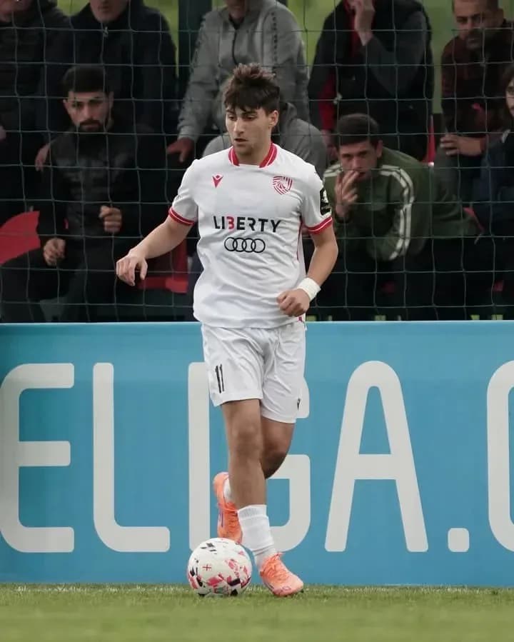 Futbolchi maydonda to'p bilan harakat qilmoqda
