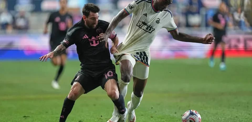 Lionel Messi challenging a Philadelphia player for the ball