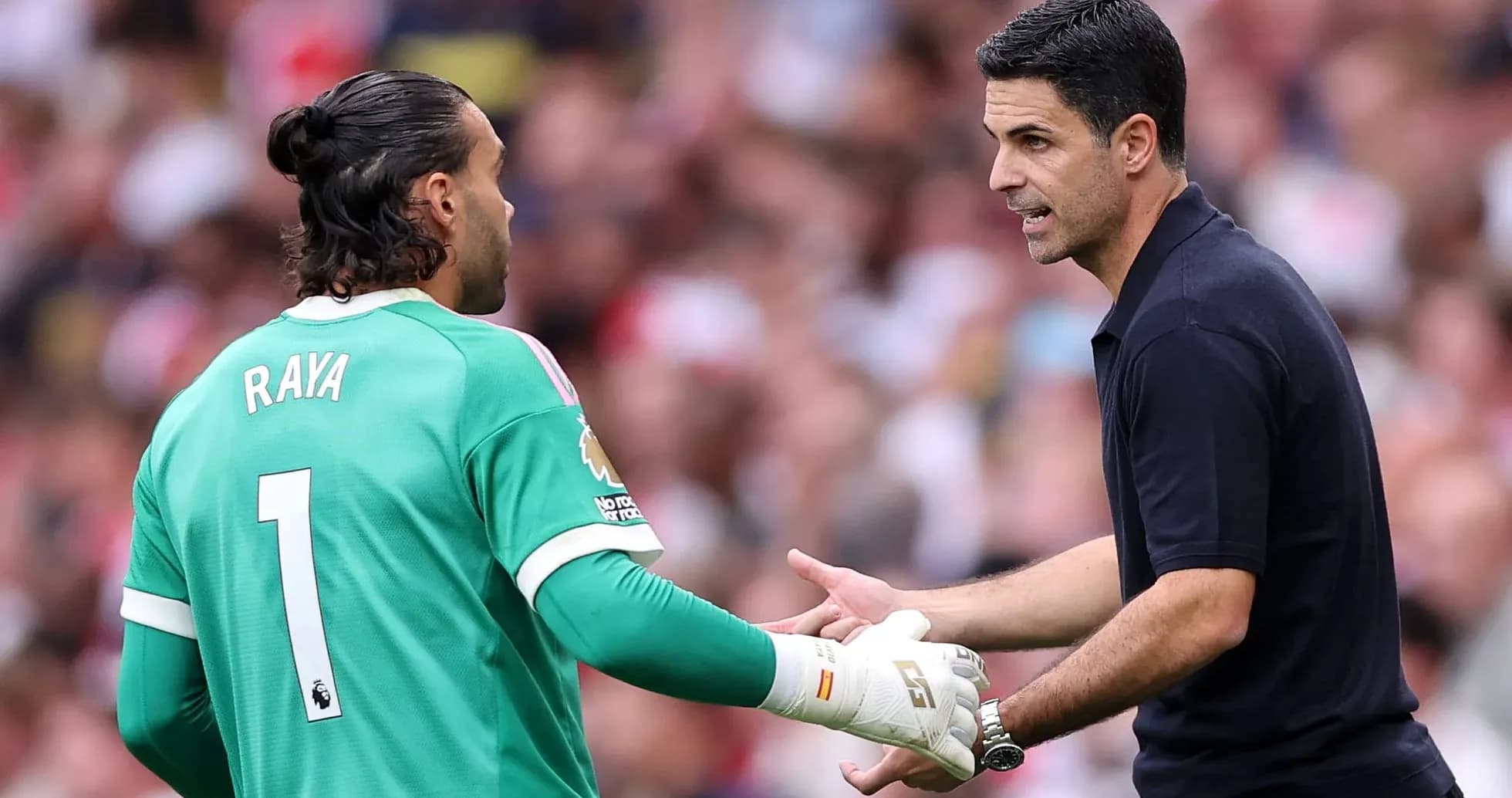 Goalkeeper and coach discussing during match