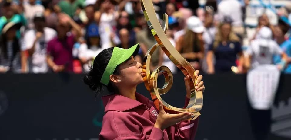 Tennis player kissing trophy after victory