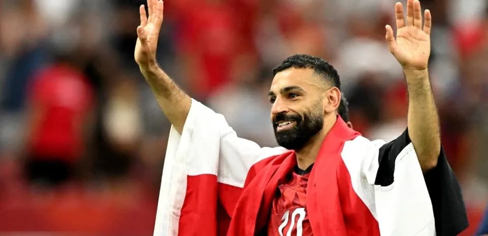 Futbolchi qo'lini ko'tarib ommaga salom bermoqda