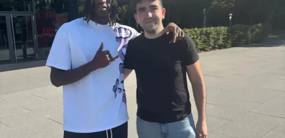 Two individuals posing together outdoors