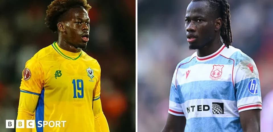 Two football players in team kits during match