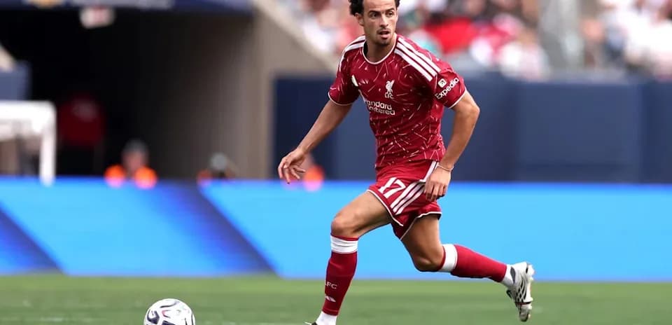 Futbolchi to'p bilan yugurmoqda, Liverpool formasi