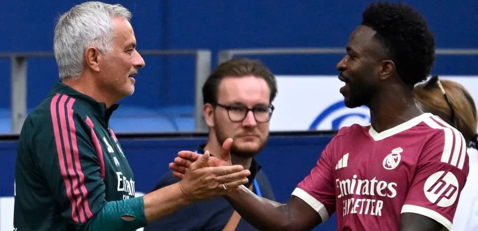 Coach and player shaking hands on the pitch
