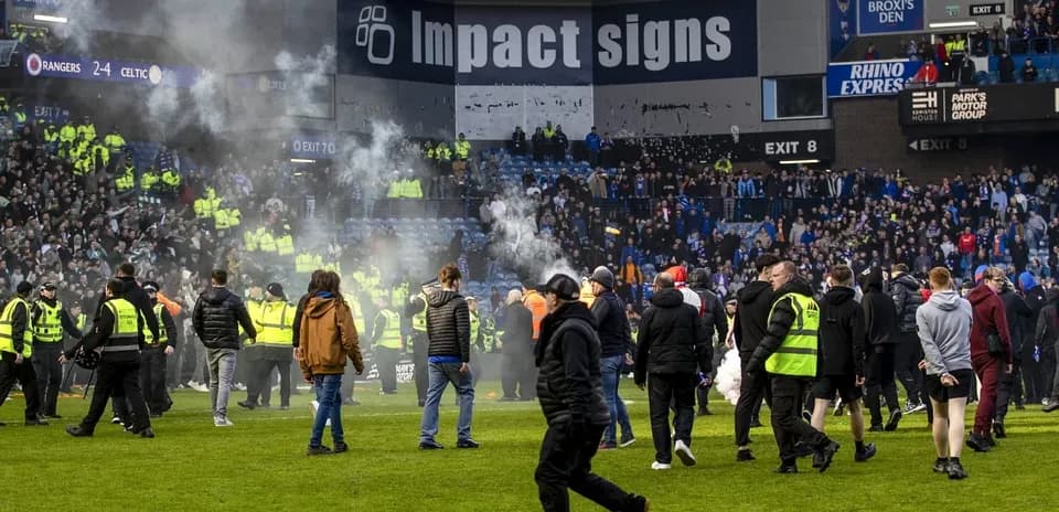 Fans and security on the pitch after match