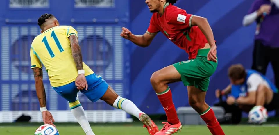 Brazillian player dribbling past Moroccan defender