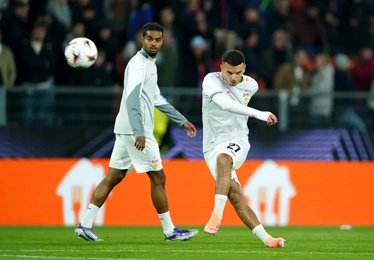 Futbolchi to'pni zarba berayotgani, boshqa futbolchi yaqinida