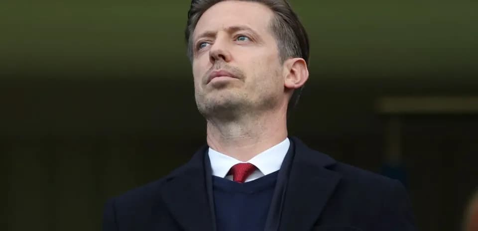 Man in formal attire observing the game
