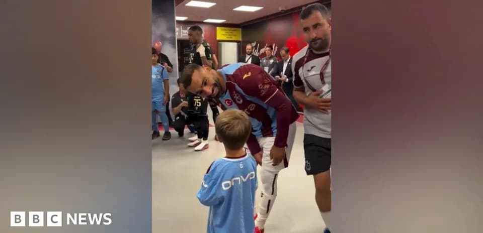 Futbolchi bolaga tabassum bilan qarab turibdi
