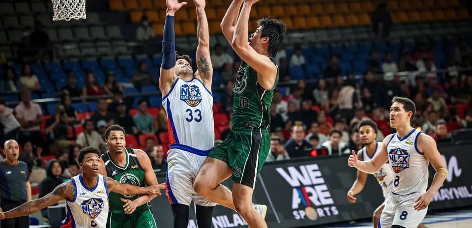 Player shooting basketball while defended by opponent