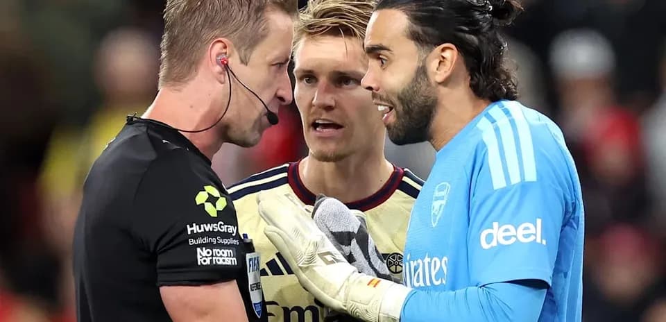 Goalkeeper and players discussing with referee during match