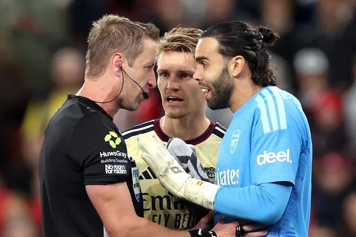 Goalkeeper and players discussing with referee during match