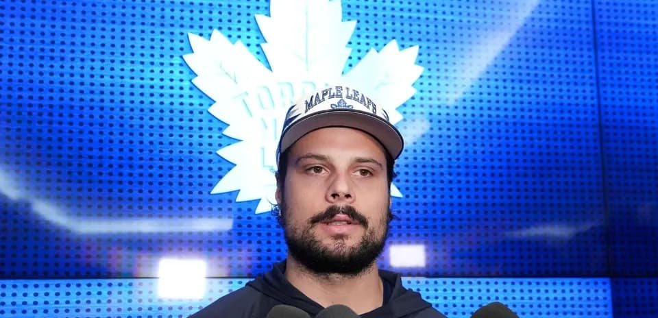 Player speaking at press conference with microphones