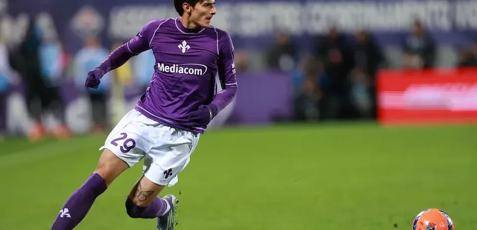 Fiorentina player running after the ball on field