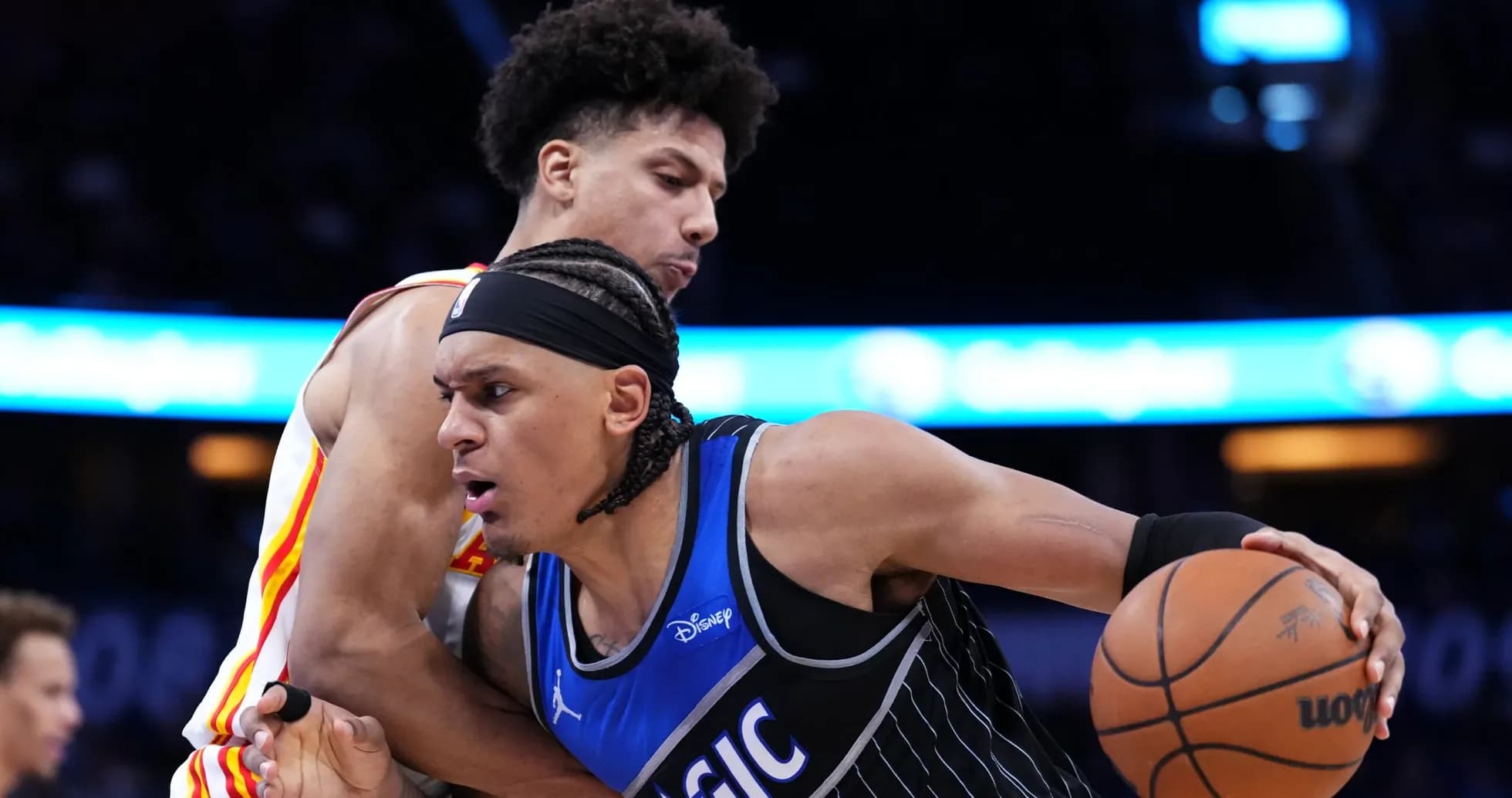 Two basketball players competing for possession of the ball