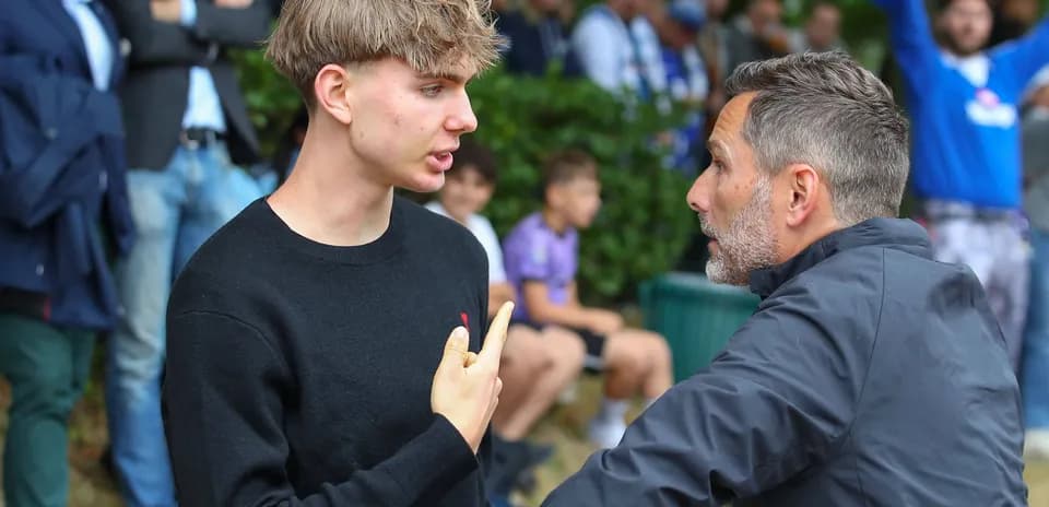 Young man talking to an older man in crowd