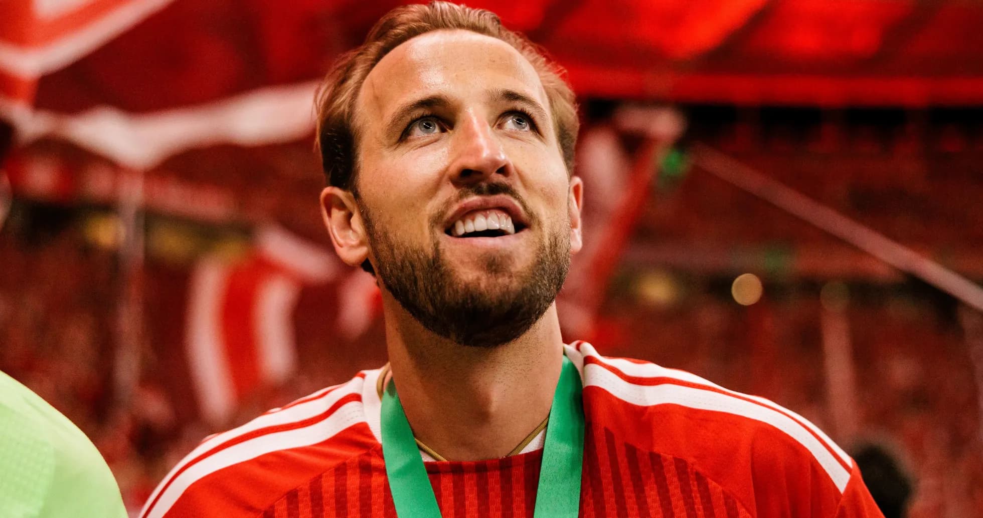 Futbolchi medali bilan maydonni tomosha qilmoqda