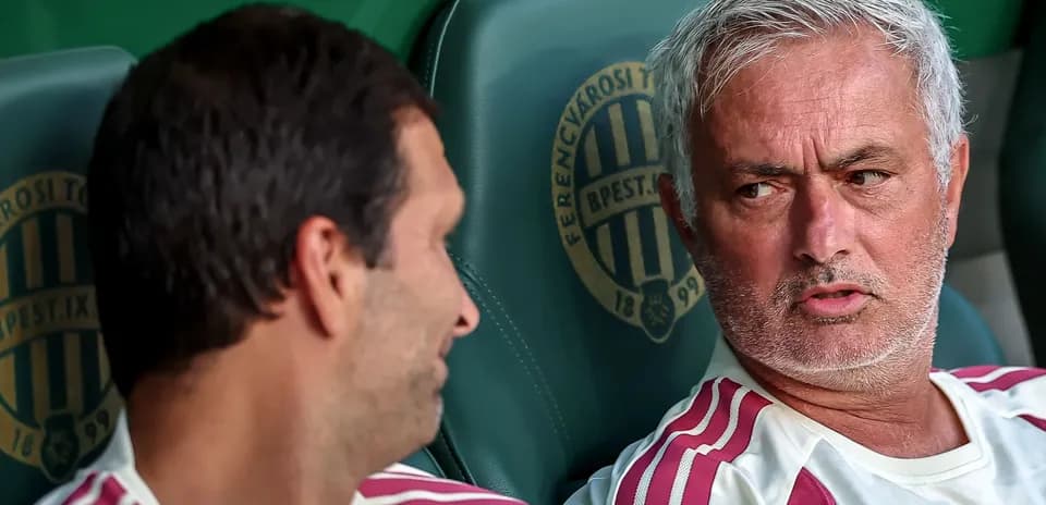 Two coaches discussing on team bench during match