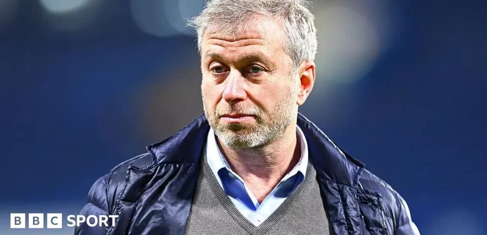 Man in a jacket standing at sports venue