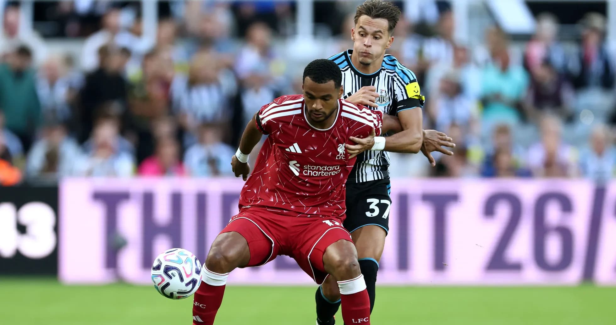 Liverpool player being challenged by Newcastle opponent