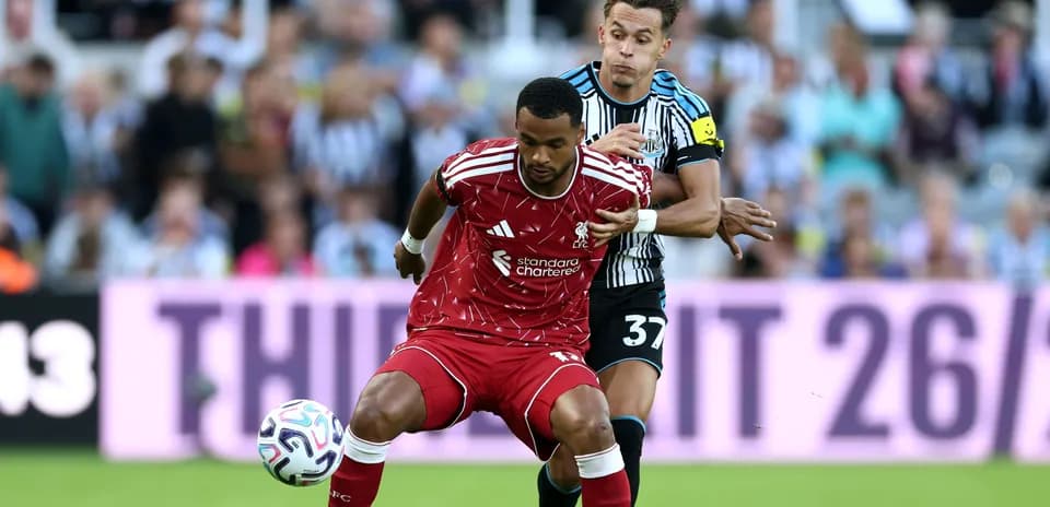 Liverpool player being challenged by Newcastle opponent
