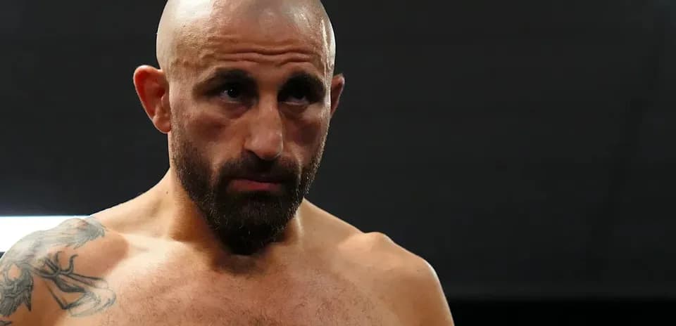 Bald fighter with tattoos preparing for match