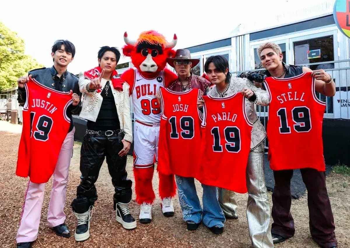 Group of five holding basketball jerseys with mascot
