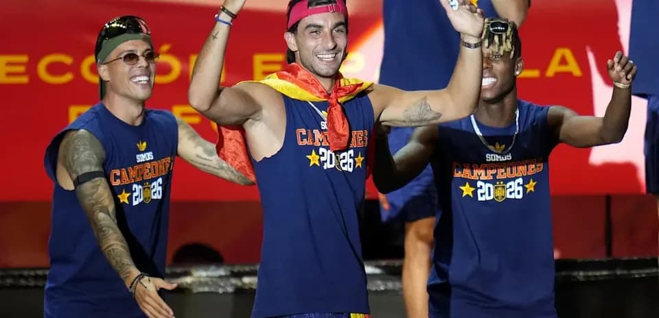 Futbolchilar chempionlik bayrog'ini ko'tarib turishmoqda