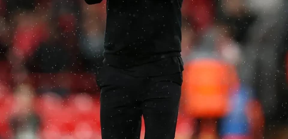 Men's football coach applauding on the pitch