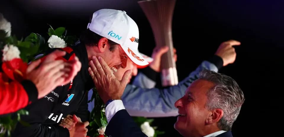 Driver celebrating victory on podium with trophy