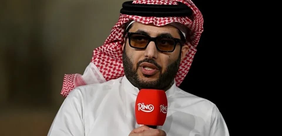 Shirted man speaking into a microphone during interview