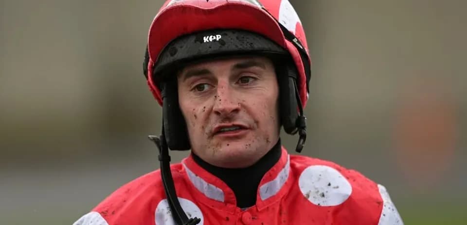 Jockey wearing red and white silks after race