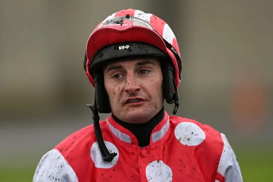 Jockey wearing red and white silks after race