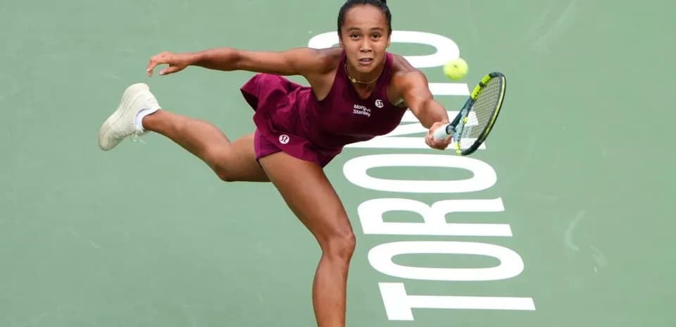 Tennis player reaching for a ball on court