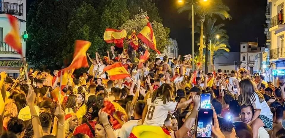 Odamlar Ispaniya bayrog'ini tutib, bayram qilmoqda
