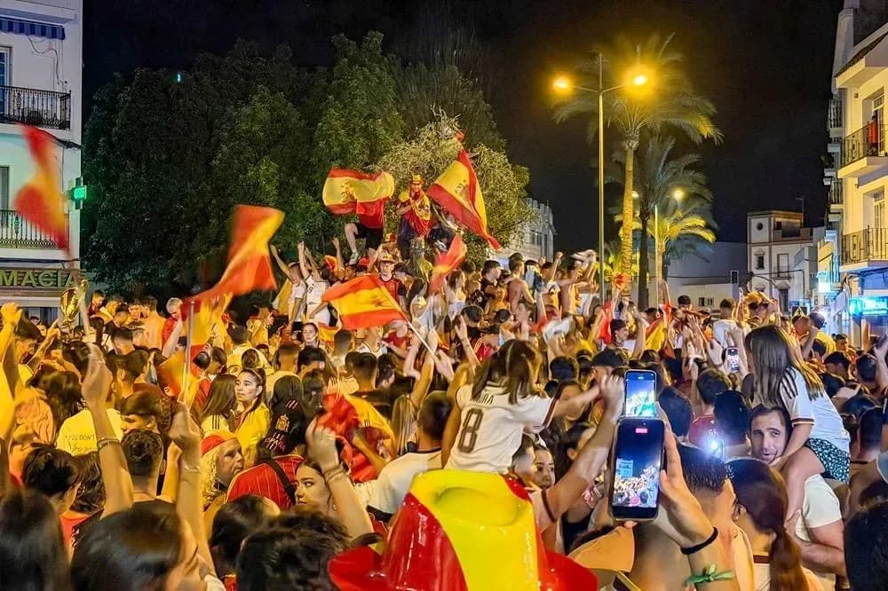 Odamlar Ispaniya bayrog'ini tutib, bayram qilmoqda