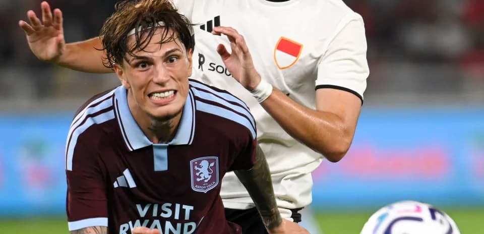 Aston Villa player challenged by opponent during match