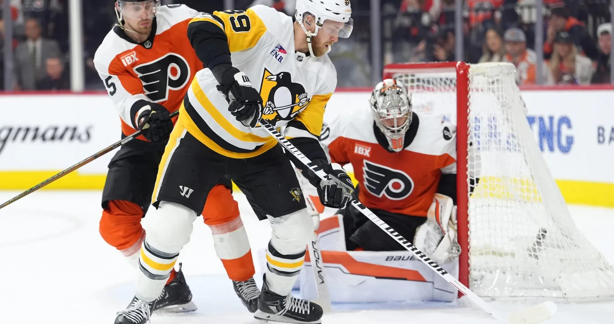 Hockey players battling for puck near goal