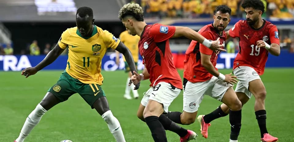 Australia player dribbling past Egyptian defenders in match