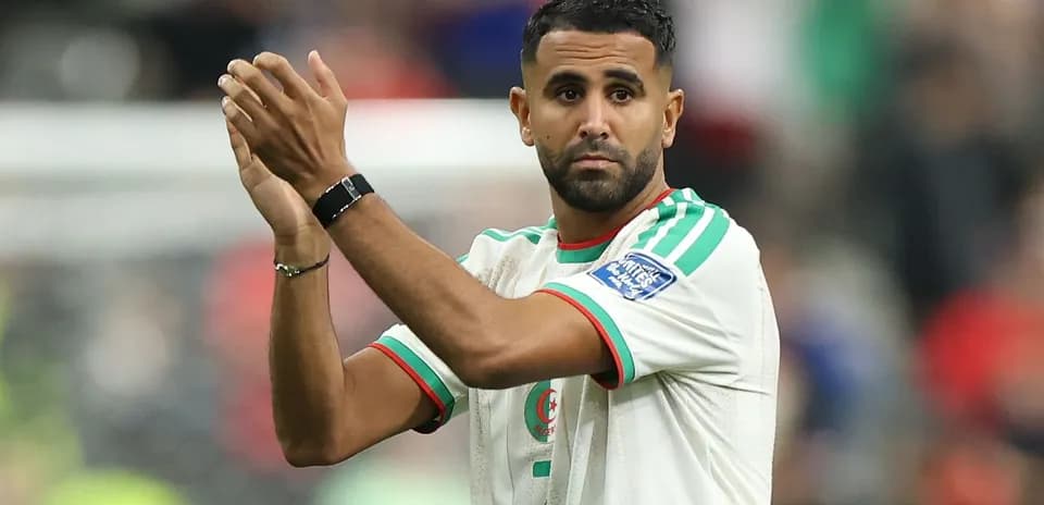 Futbolchi sahna ustida qo'llarini ko'tarib turibdi