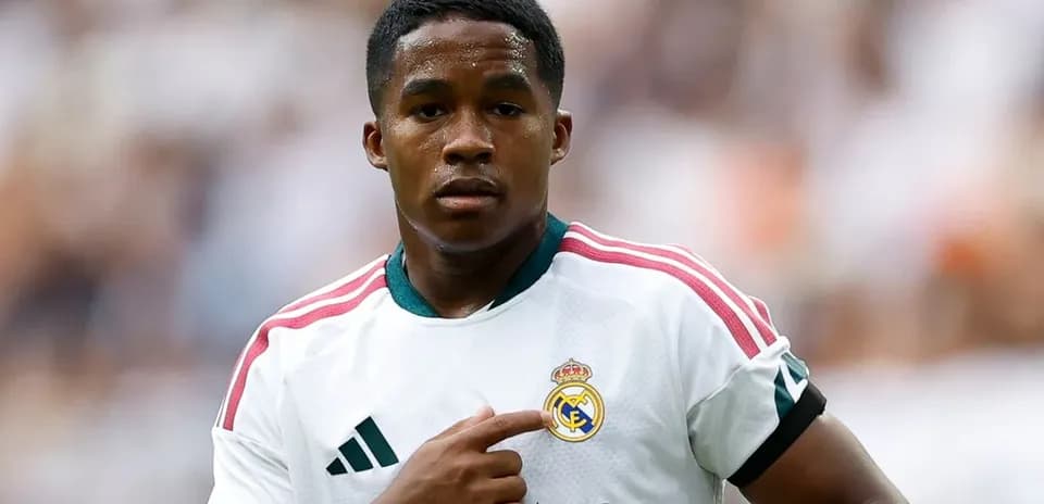 Futbolchi Real Madrid formasida jamoa emblemiga ishora qiladi