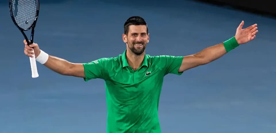Tennis player celebrating with arms raised in victory