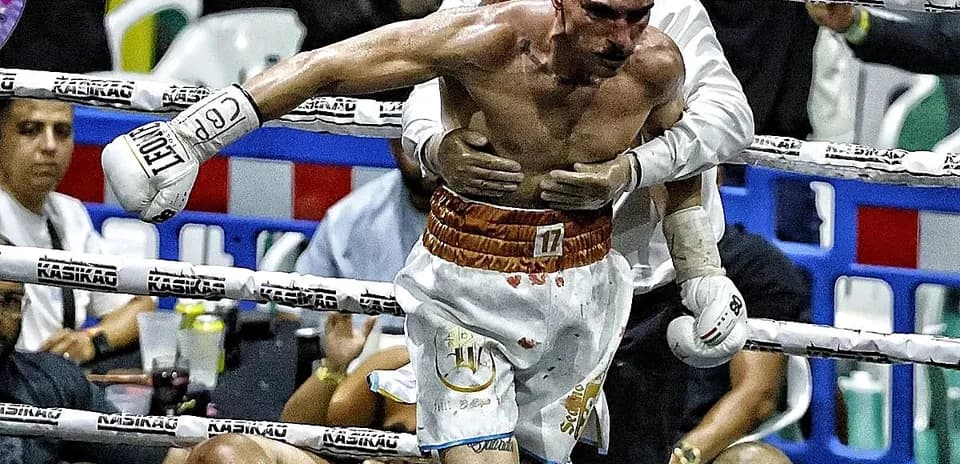 Boxer being assisted after a knockout in the ring