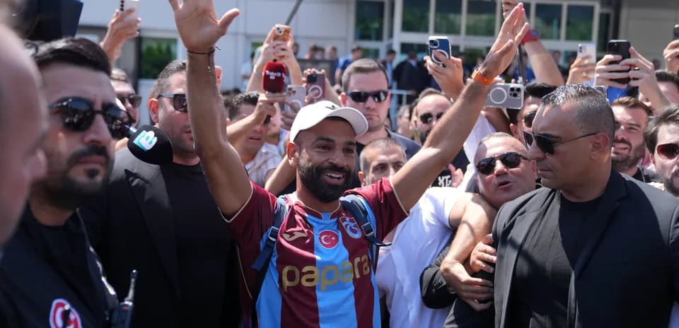 Football player greeted by fans at airport arrival