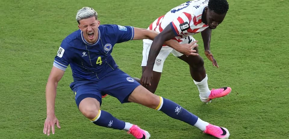 Bosnia player falling while challenged by USA player