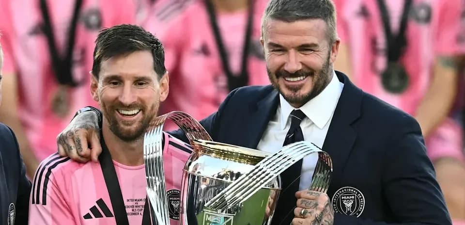 Lionel Messi and David Beckham holding trophy